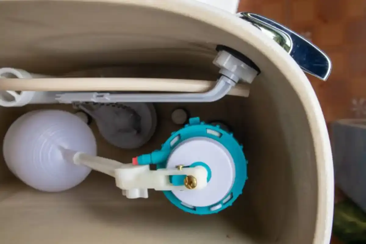 Inside of a toilet tank showing the fill valve and float
